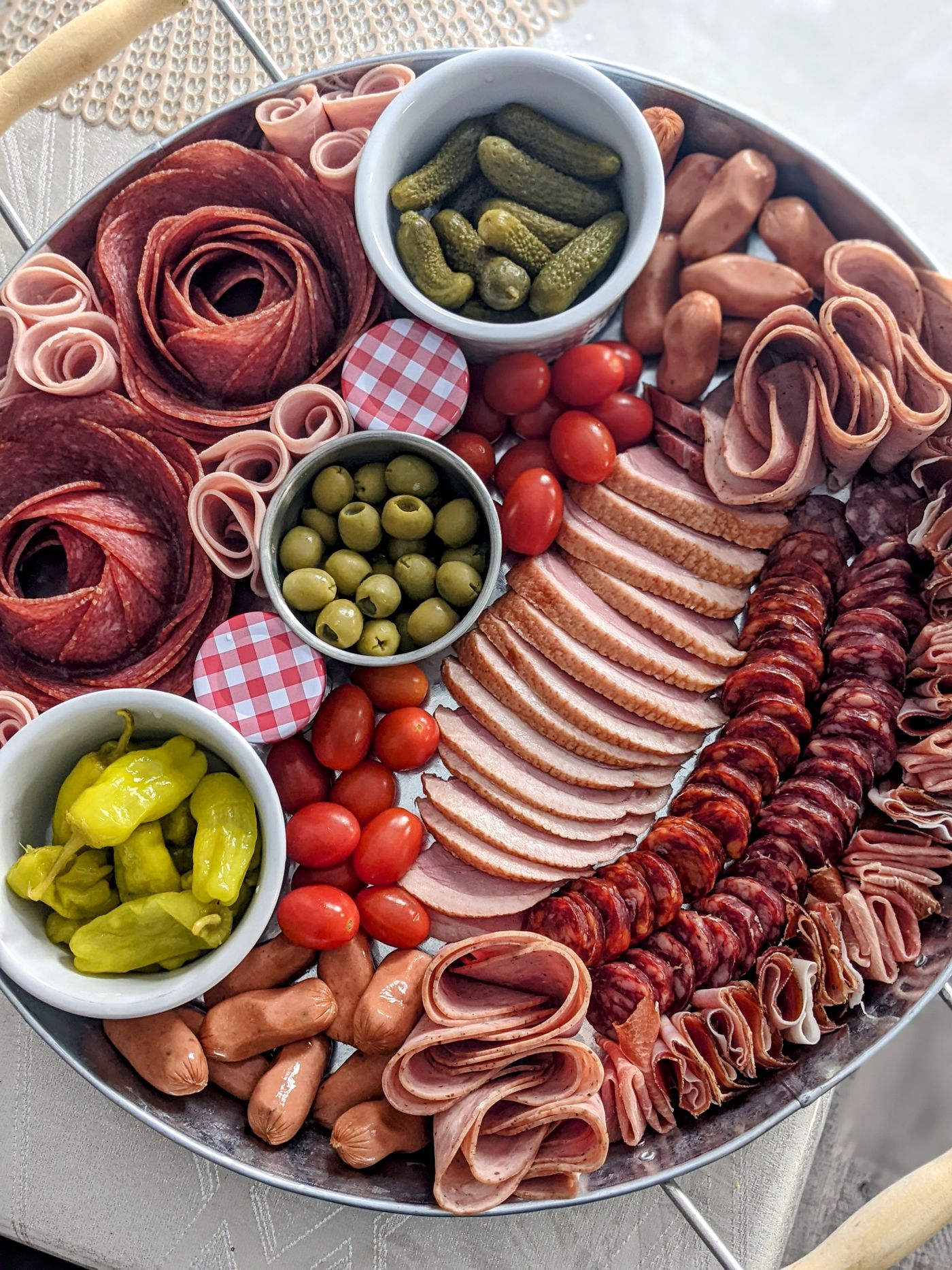 Liebevoll angerichtete Aufschnittplatte mit Wurst, Schinken, Oliven, Gurken und Tomaten